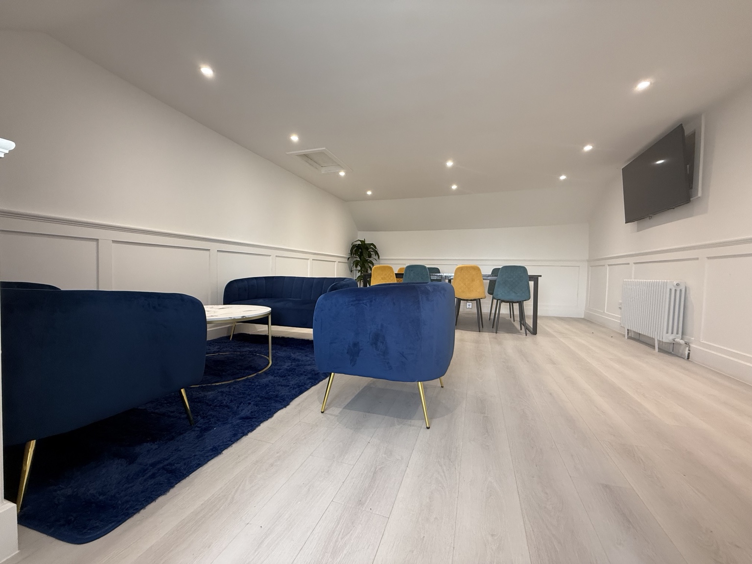 The Boardroom with lounge seating, meeting table and wall-mounted presentation screen